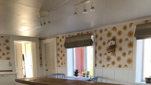 Eine Küche mit Kochinsel, weißen Schränken und einer Holz Arbeitsplatte.
