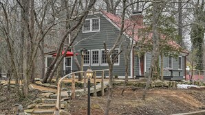 A house with a red roof, stone steps, and a wooden fence. - Warm + Peaceful Home w/ Fire Pit on Haw River (Pittsboro)