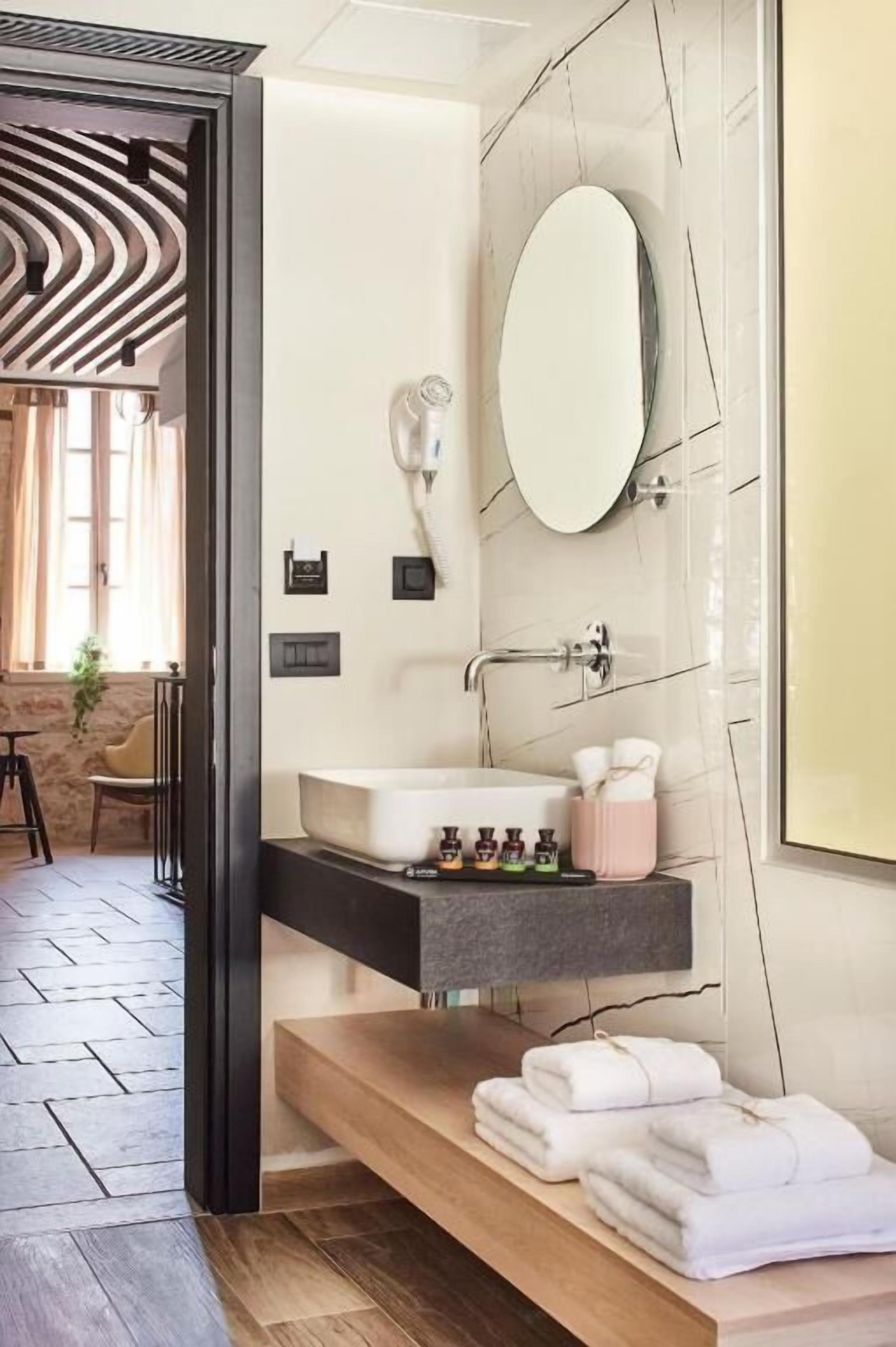 A modern bathroom with a freestanding bathtub, a vanity with a mirror, and a towel rack.
