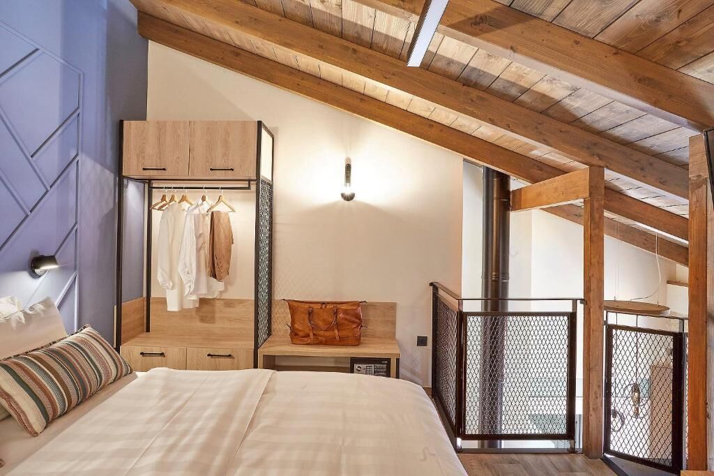 Ein Schlafzimmer mit einem Bett, einem Holzschrank und einer Kleiderstange.