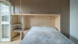 A bedroom with a bed, a wardrobe, a desk, and a shelving unit. - LA TERRAZZA A SECCHETO SUL MARE (Campo nell'Elba)