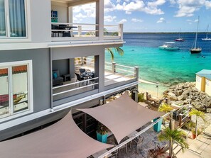 A multi-level building with outdoor seating and a view of the ocean.
