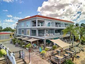 A two-story building with outdoor seating and a covered patio area. - Den Laman Tuna directly on the sea with amazing views (Kralendijk)