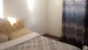 Una camera da letto con un letto, un comodino e una mensola a parete.