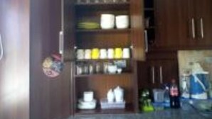 Una cucina con mobili in legno, un piano di lavoro e diversi oggetti da cucina.