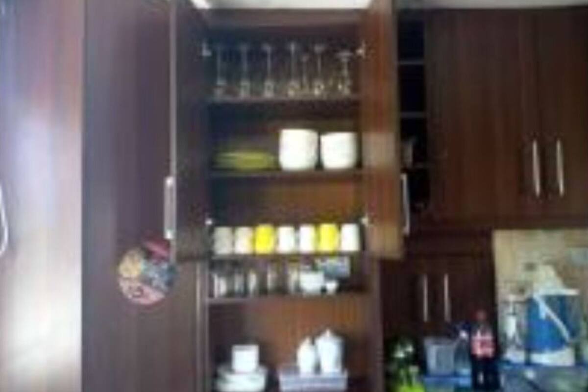 A kitchen with wooden cabinets, a countertop, and various kitchen items.