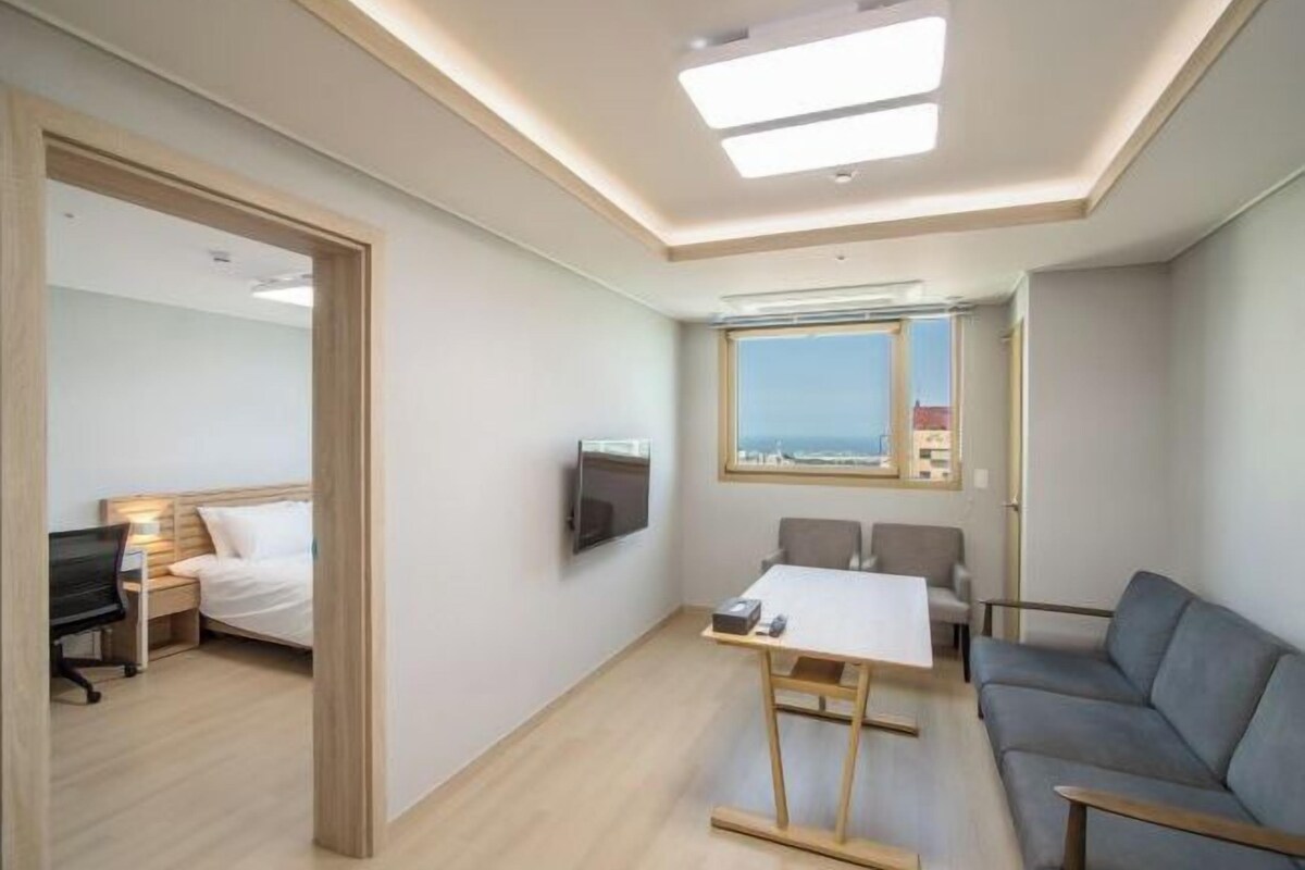Une chambre d’hôtel moderne équipée d’un lit, d’un bureau et d’un coin salon.