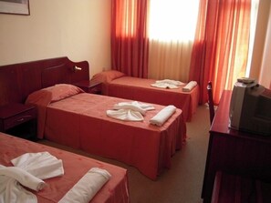 A hotel room with two beds, a desk, a chair, and a television. - Dahlia Garden (Varna)