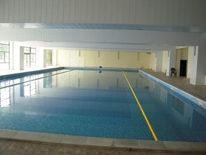 An indoor swimming pool with clear water, tiled walls, and a simple layout. - Dahlia Garden (Varna)