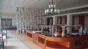 Zona tipo bufé con una isla central, varias estaciones de servicio y un techo con una lámpara decorativa.