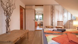 Un dormitorio con una cama de madera, una mesita de noche, una silla y vistas a un comedor.