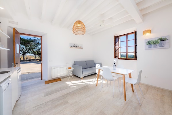 Un intérieur moderne comprenant un coin repas, un canapé et une cuisine.