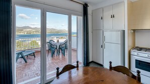 Une cuisine donnant sur un balcon, avec une table à manger et un fourneau.