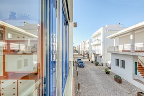 A narrow street with buildings on either side, a clear sky, and a few cars parked along the road. - Holiday Home "Casa centro port" Near Beach with Sea View & Balcony (Llançà)