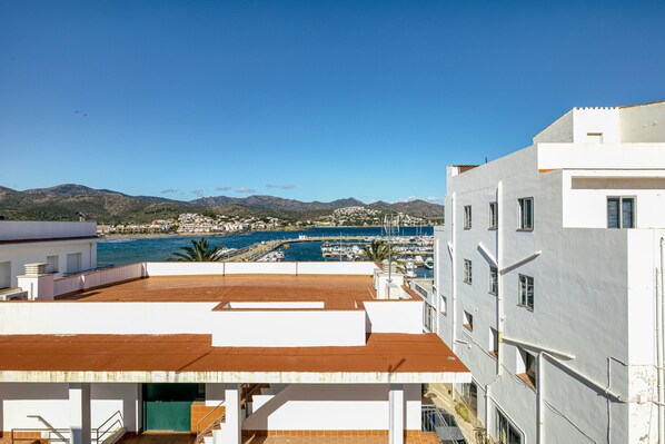 A coastal building with a view of the sea and mountains.