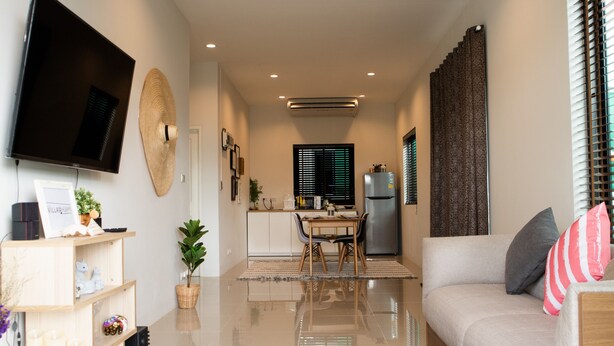 A modern living room with a flat-screen TV, a sofa, a dining area with chairs, and a kitchen in the background. - Hua-Hin Private pool villa (Tambon Hin Lek Fai, Amper Hua-Hin)