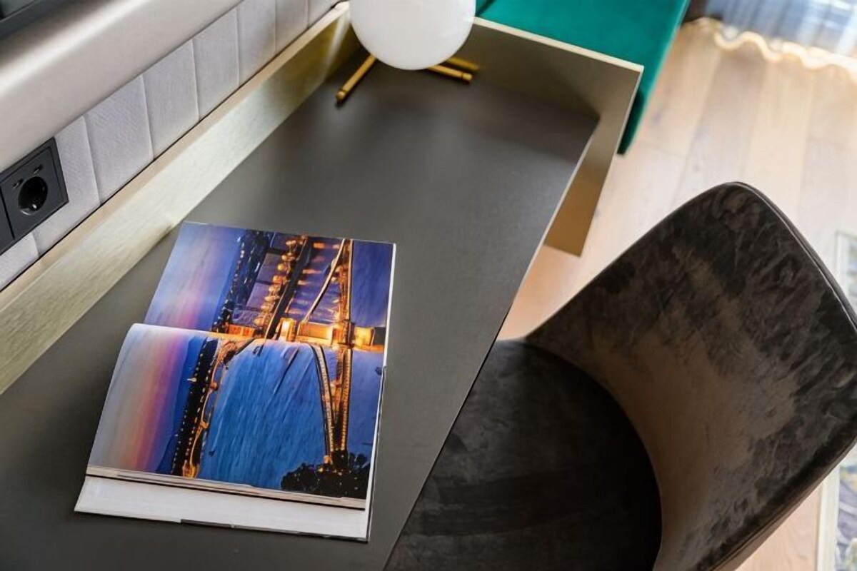 Una revista sobre una mesa, con vista a un puente.