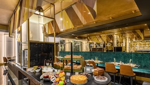 Zona de bufé con diferentes opciones de comida y disposición de mesas.