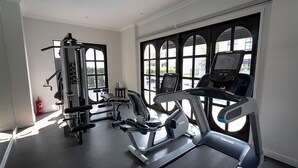 Uma academia com equipamentos de cardio, máquinas de peso e esteira.