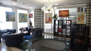 A modern living room with a glass coffee table, black leather sofas, and a decorative metal cage. - Hotel Duca d'Aosta (Mogliano Veneto)
