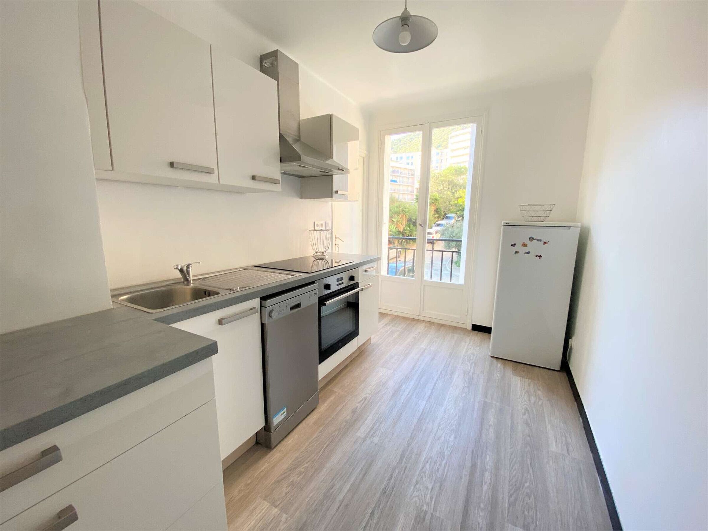 A modern kitchen with a dishwasher, oven, and a refrigerator.