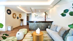 A reception area with a wooden reception desk, a white sofa, and a patterned rug.
