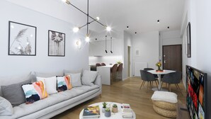 Ett modernt vardagsrum med en soffa, ett soffbord och en matplats med stolar.