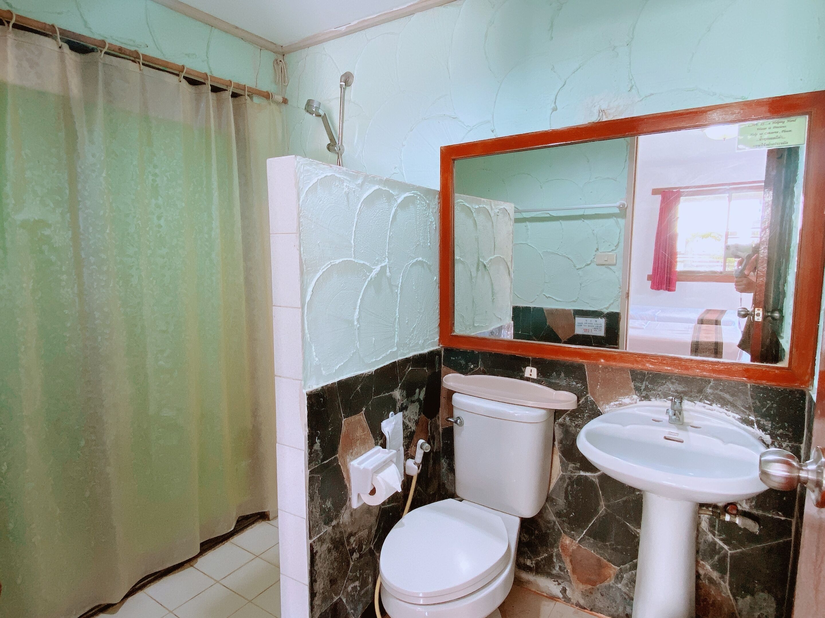 Ein Badezimmer mit Toilette, Waschbecken und Spiegel.