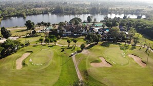Ein Golfplatz mit Bunkern und einem Clubhaus.