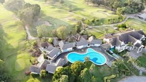 Eine Vogelperspektive auf einen Golfplatz mit einem Schwimmbad und Villen.