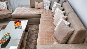 A modern living room with a large sectional sofa, a glass coffee table with fruit, and a small side table. - Fairy Tale 1 BDR Apartment in City Center (Žabljak)