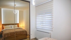 A bedroom with a bed, a radiator, and a window with blinds. - Fairy Tale 1 BDR Apartment in City Center (Žabljak)