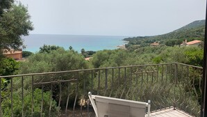 A balcony with a view of the sea and surrounding greenery. - Demi Villa Dans u Quartier Résidentiel Avec Accès Privé à la Plage (Olmeto)