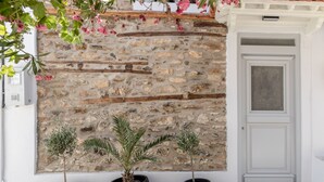 Un mur de pierres devant lequel se trouvent trois plantes en pot.
