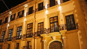 A multi-story building with ornate balconies and large windows, likely a hotel or historic building. - HomeMuseum (Palermo)