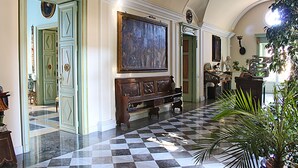 A lobby with a checkered floor, a large painting, and a statue. - HomeMuseum (Palermo)