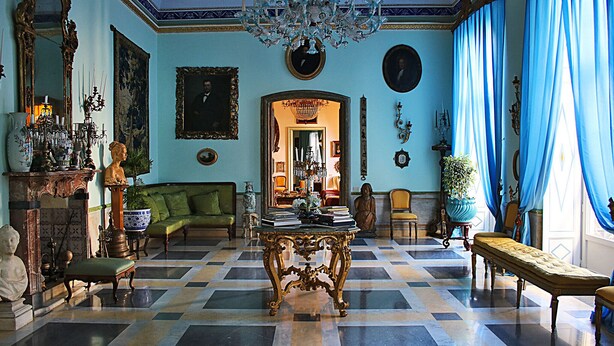 A grand room with a checkered floor, a large ornate table, and a chandelier. - HomeMuseum (Palermo)