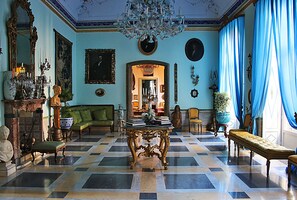 A grand room with a checkered floor, a large ornate table, and a chandelier. - HomeMuseum (Palermo)