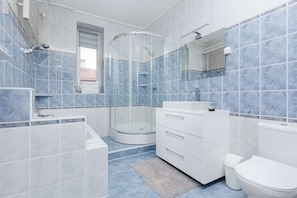 Bathtub, hair dryer, towels, shampoo
