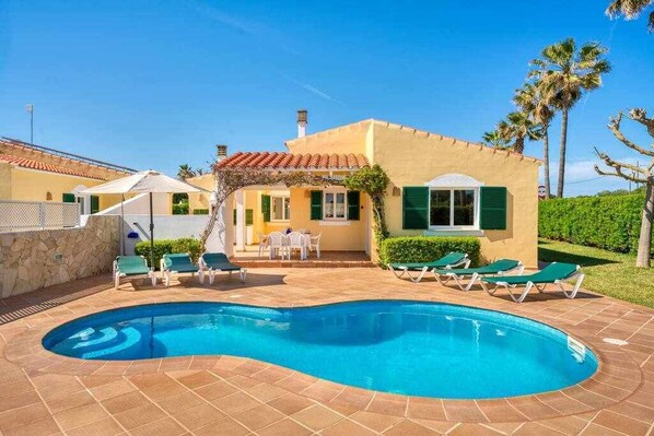 A swimming pool with lounge chairs and a patio area. - Linardo 1, Villa with pool and air conditioning (Ciutadella De Menorca)