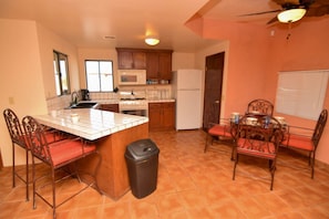 Enjoy cooking in this well-equipped kitchen with a central island, sink, stove, and microwave.