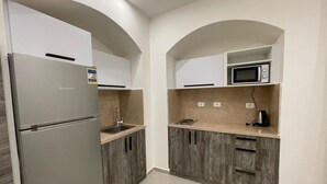 Una cocina moderna con refrigerador integrado, microondas y armarios de madera.