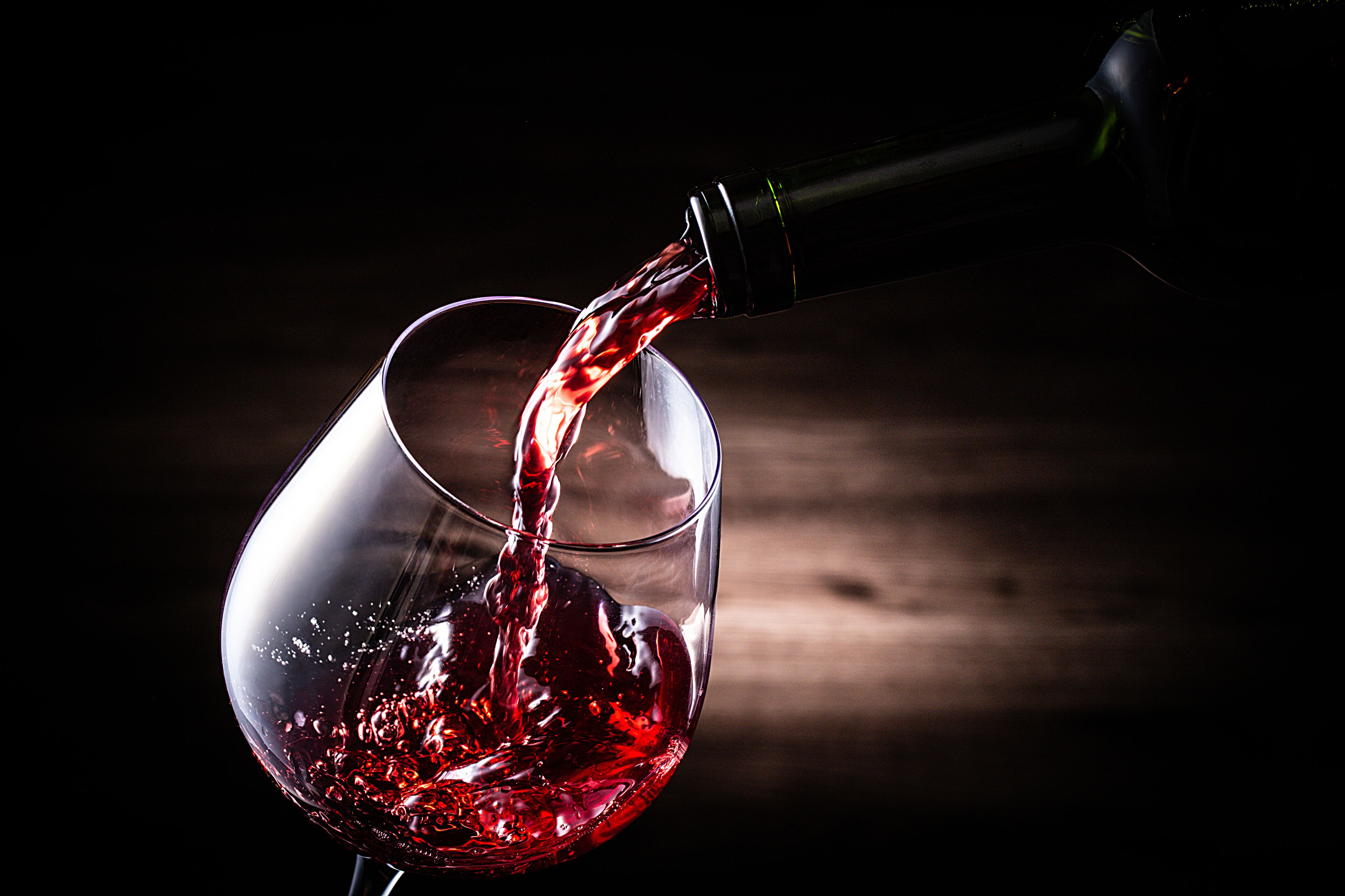 Vino tinto siendo servido desde una botella.