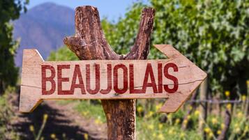 Un panneau en bois portant le mot « BEAUJOLAIS » et pointant vers la droite.