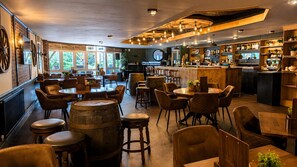 A bar area with wooden furniture, a bar counter, and a seating area with round tables and chairs. - The Park Hotel, Sure Hotel Collection by Best Western (Diss)