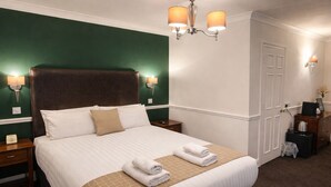 A neatly made bed with white linens and a brown throw, a nightstand with a lamp, and a wall-mounted light fixture. - The Park Hotel, Sure Hotel Collection by Best Western (Diss)