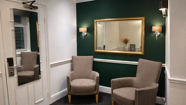 A hallway with two armchairs, a mirror, and wall sconces. - The Park Hotel, Sure Hotel Collection by Best Western (Diss)