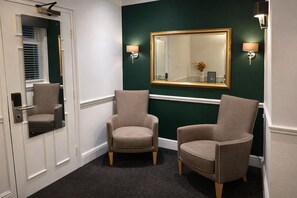 A hallway with two armchairs, a mirror, and wall sconces. - The Park Hotel, Sure Hotel Collection by Best Western (Diss)