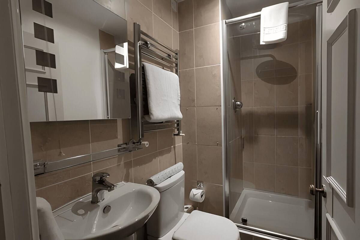 A modern bathroom with a sink, toilet, and glass-enclosed shower.