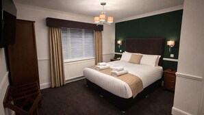 A hotel room with a large bed, a wooden wardrobe, a desk, and a television. - The Park Hotel, Sure Hotel Collection by Best Western (Diss)